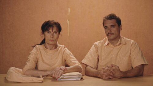 La folle vita, Jo Deseure e Jean Le Peltier seduti a una scrivania.